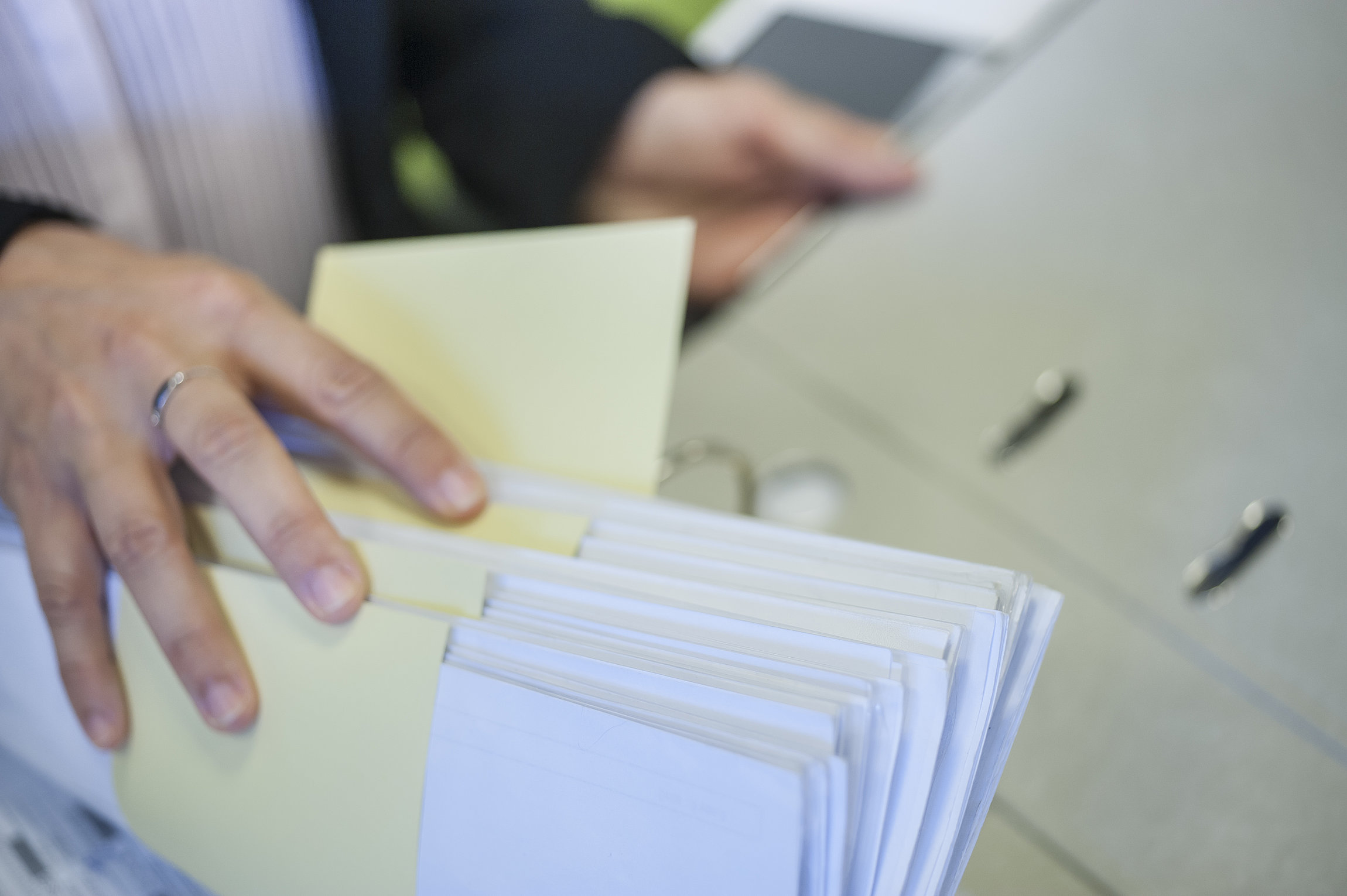 Hand blättert in Unterlagen