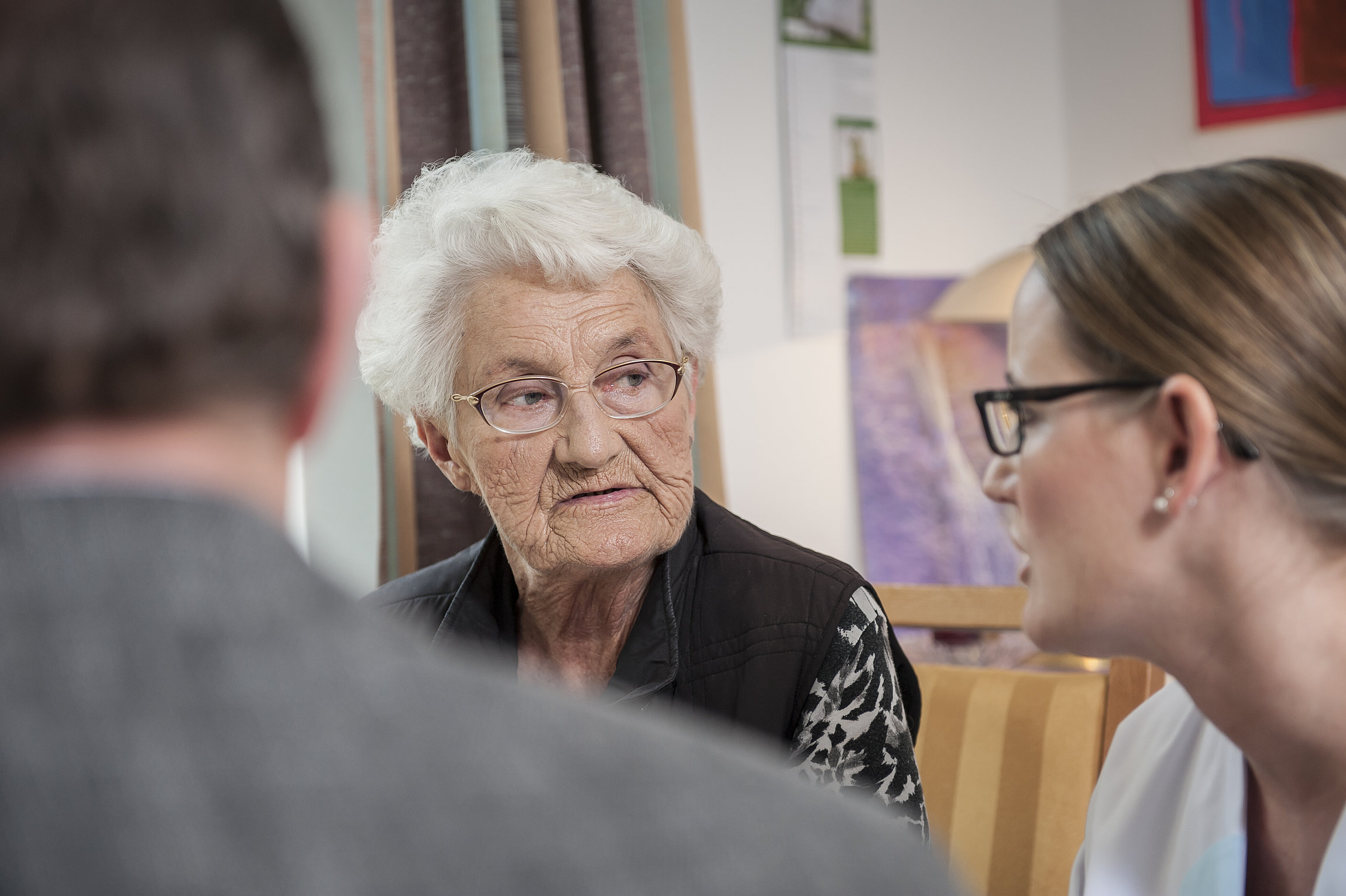 Mann von hinten und junge Frau und alte Frau